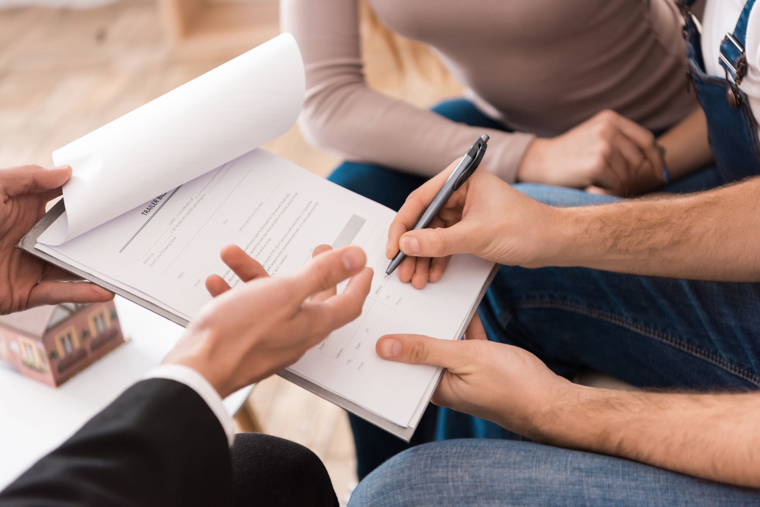 Close up of man signing agreement, family buying new apartment in real estate agency