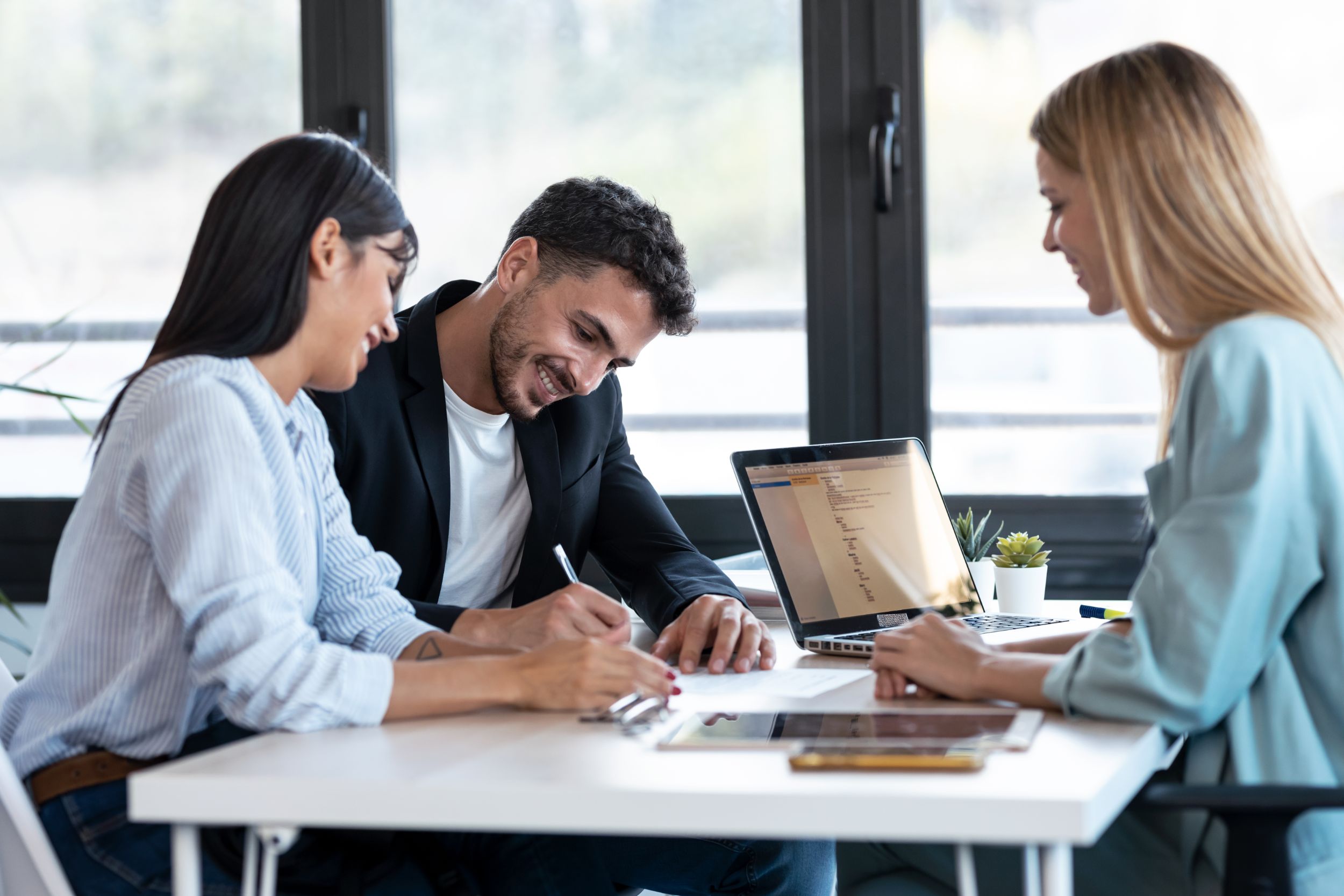 Happy young couple signing bank loan agreement with real-estate